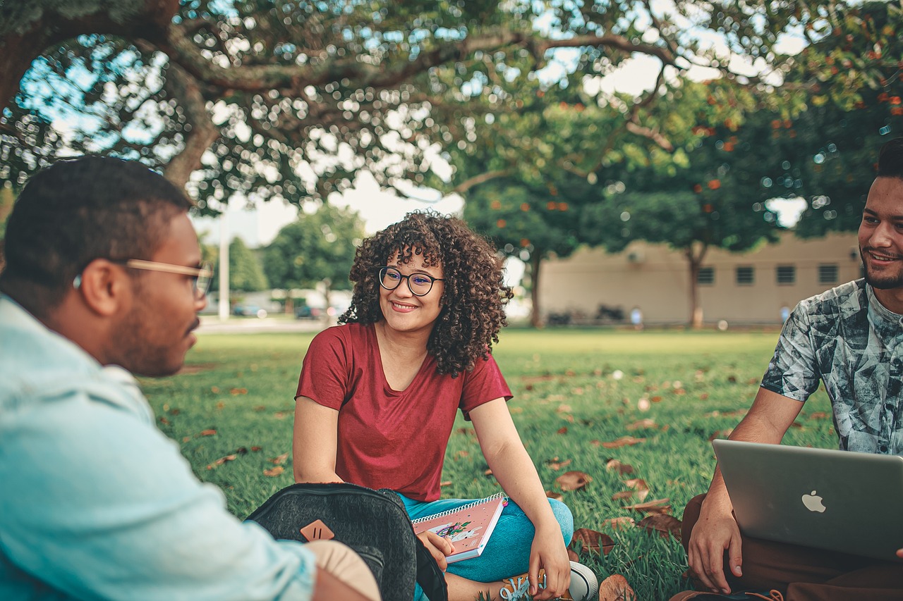 Image d'étudiants heureux à l'extérieur en train de discuter à l'université.